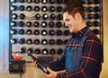 He knows his wine. a handsome young man choosing a bottle of wine in a restaurant. Royalty Free Stock Photo