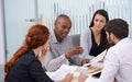 He knows how to get the best out of his team. A group of coworkers sitting in an office and having a meeting.