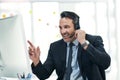 He knows how to sell a brand. a mature businessman using a headset while working on a computer in an office. Royalty Free Stock Photo