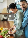 She knows the way to a mans heart. Portrait of an affectionate young couple preparing a meal together in their kitchen. Royalty Free Stock Photo