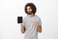 He knows what gadgets worth buying. Satisfied pleased male customer with beard and stylish haircut in striped shirt Royalty Free Stock Photo