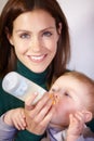 She knows whats best for him - Infant nutrition. Pretty young mother bottle-feeding her infant son.