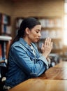 She knows where her strength comes from. an attractive young woman praying for help with her upcoming university exams.