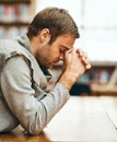 He knows where his strength comes from. a handsome young man praying for help with his upcoming university exams.