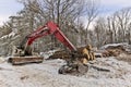 Knuckleboom Log loader with Freshly Harvested and piled timber logs