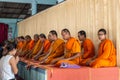 Devotees in front of Row of praying Buddhist monks on Ko Samui Island, Thailand