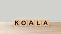 Koala - word wooden cubes on table horizontal over gray background. Australia animal, australian emergency, help fire emblem Royalty Free Stock Photo