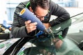 Koblenz Gerrmany 04.04.2018 man using repairing equipment to fix damaged cracked windshield at wintec company