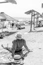 Koblevo, Ukraine - June 21, 2021: Overweight woman in swimsuit on her back, sitting on the beach sand, looking out to sea. Obes