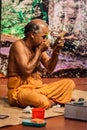 Kathakali exponent preparing for performance by applying face make-up. Kathakali is the classical dance form of Kerala