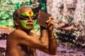 Kathakali exponent preparing for performance by applying face make-up. Kathakali is the classical dance form of Kerala