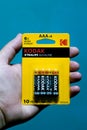 Kodak battery pack with 10 year warranty. Kodak promises 6 x more power. Battery pack held in hand with a blue background