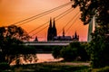 Koelner Dom - Cologne Cathedral - behind the Severin Bridge while Sundown with orange sky riverside and water