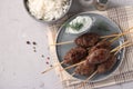 Kofta kebab on wooden skewers on a plate with sauce and a side dish of rice on the table, traditional dish of Arab cuisine, Royalty Free Stock Photo