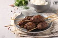 Kofta kebab on wooden skewers on a plate with sauce and a side dish of rice on the table, traditional dish of Arab cuisine, Royalty Free Stock Photo