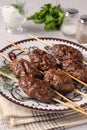 Kofta kebab on wooden skewers on a plate and sauce on the table, traditional dish of Arab cuisine, grilled minced meat Royalty Free Stock Photo