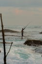 Silhouettes of the traditional Sri Lankan stilt fishermen on a stormy in Koggala, Sri Lanka. Stilt fishing is a method of fishing