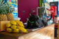 Koh Chang island, Thailand - August, 2019. A serious-looking black cat lies on a fruit counter