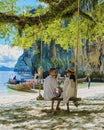 Koh Lao Lading near Koh Hong Krabi Thailand, beautiful beach with longtail boats, couple European men and Asian woman on
