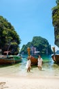 Koh Lao Lading near Koh Hong Krabi Thailand, beautiful beach with longtail boats, couple European men and Asian woman on