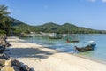 Beautiful bay with palm trees and boats. Tropical beach and sea water on the island Koh Phangan, Thailand