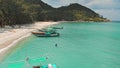 Traditional colorful boats on sandy beach shore in Koh Phangan exotic island in Thailand