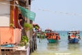 Koh Rong island, Cambodia - 07 April 2018: sea view with boat, house on piles and woman watering flowers