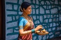 Indian women statue, wearing pink color saree, blue color bangles and traditional jewelry and holding copper worshiping plate at Royalty Free Stock Photo