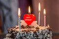 Celebrating wedding anniversary with a beautiful heart shape candle on cake Royalty Free Stock Photo