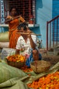 Indian seller weighs flowers by scales on Flower market at Mallick Ghat in Kolkata. India