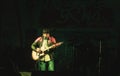 Kolkata India 1 May 2019: Guitarist performing on. Rock Concert venue with lit bright colorful stage lights and silhouette of fans Royalty Free Stock Photo