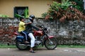 Kolkata, India - October 27, 2020 : local indian father try to starting old motorcycle to sending his child to school in the