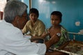 A paediatrician is checking a little boy with stethoscope.