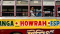 An Indian male passenger sitting in a colorfully painted public transport bus in the