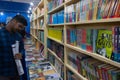 Kolkata, West Bengal, India - 2nd February 2020 : Young man with book fair ground map in hand, reading book covers of books on Royalty Free Stock Photo