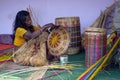 A senior craft woman making bamboo basket in a fair.