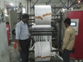 White Paper Reels are being slitted from bid roll before being used as bottom of