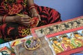 A woman artist painted on a earthen pot in a handicraft fair.