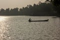 Silhouette of a fisherman on a wooden canoe in the waters of the Ashtamudi lake in Quilon Royalty Free Stock Photo