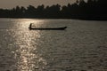 Silhouette of a fisherman on a wooden canoe in the waters of the Ashtamudi lake in Quilon Royalty Free Stock Photo