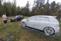 Kolomna, Russia - April 1, 2019: A man washes his car against the background of the forest. Tuned Volkswagen Golf 6 stands on the Royalty Free Stock Photo