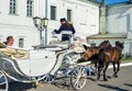 Kolomna, Russia - August 11, 2018. Elegant white carriage with coachmen in black hat and brown horses carrying tourists