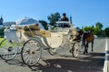 Kolomna, Russia - August 11, 2018. Elegant white carriage with coachmen in black hat and brown horses carrying tourists