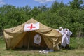 KOLYVAN, RUSSIA - JUNE 12, 2022: People dressed in the costumes of doctors and orderlies near a tent with red crosses are Royalty Free Stock Photo