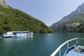 Koman, Albania, July 7 2019: A tourist boat overtakes the car ferry on Komani Lake in the dinaric alps of Albania