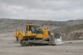 The Komatsu D375A bulldozer works in an open pit. It clears the road for mining machinery.