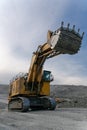 A Komatsu PC4000 excavator moves with a raised bucket in an open pit.
