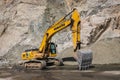 Komatsu PC300 yellow excavator in Almaty mountains, rock formation on the background