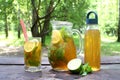 Kombucha Tea Fermented Super Food In Glass, Jug And Bottle With Mint And Lemon, Lime On Wooden Table, outdoor.