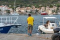 Komiza, Croatia - Aug 17, 2020: Young boy fishing at old town port during sunset on vis island Royalty Free Stock Photo